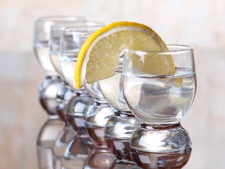 Color photo of a glass cup with tequila and lemon     の写真素材