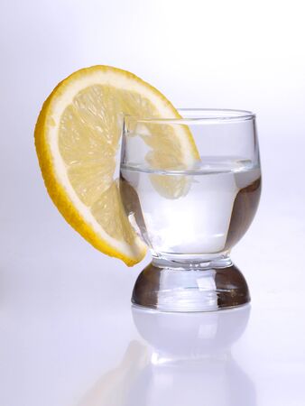 Color photo of a glass cup with tequila and lemon      の写真素材
