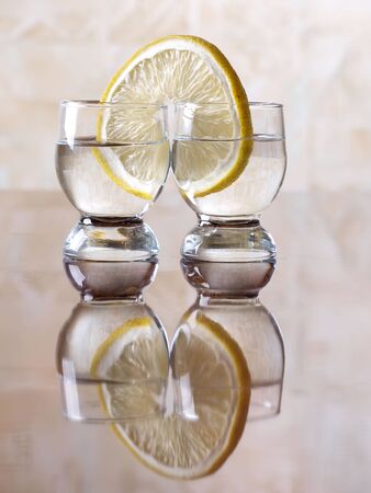 Color photo of a glass cup with tequila and lemon        の写真素材