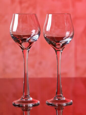 Color photo of a glass of wine glasses on red background     の写真素材
