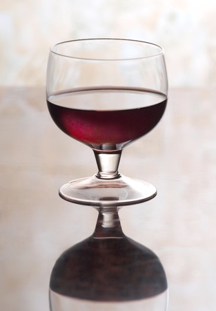Color photo of a glass of red wine glasses on mirror surface      の写真素材