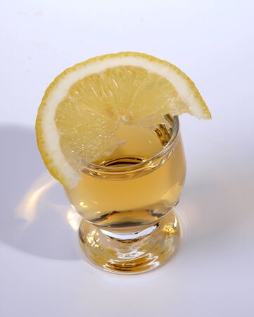 Color photo of a glass cup with tequila and lemon      の写真素材