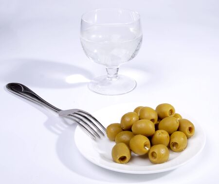 Color photo of green olives on a white plate      の写真素材