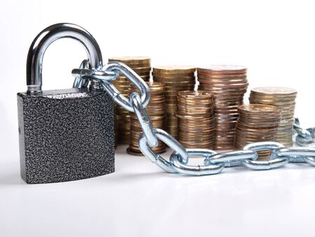 Color photo of pile of coins and a padlock with chain     の写真素材