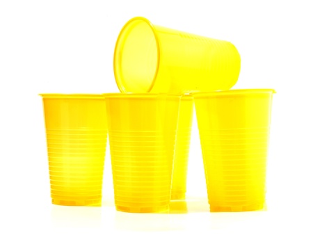 Color photograph of yellow plastic cups on a white background       の写真素材
