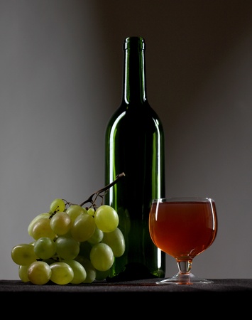 Color photo of a branch of grapes and glass bottleの写真素材