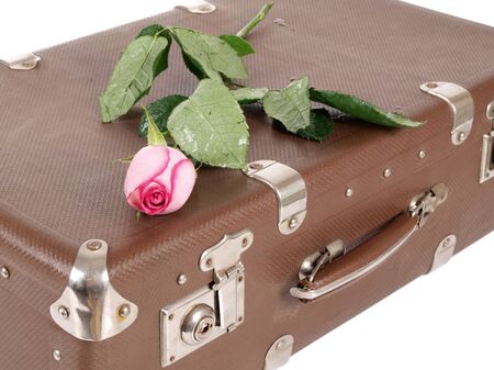 Color photo of an old suitcase and rose on white background      の写真素材