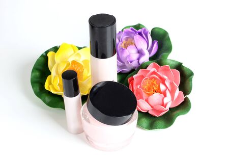 Color photo of a glass bottle with lotion and flowerの写真素材