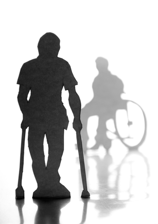 Cardboard silhouettes of people with crutches and a wheelchairの写真素材
