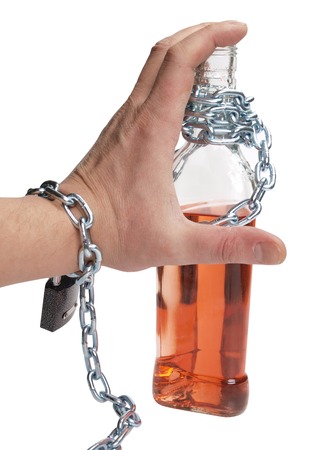 Wineglass of whiskey and metal chainの写真素材