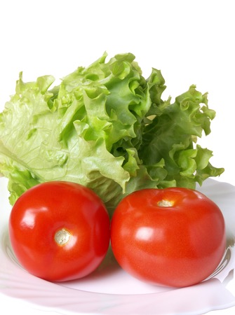 Red tomatoes and salad on whiteの写真素材