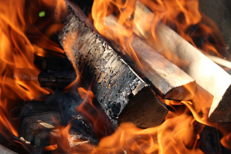 Charred wood and bright flames on dark backgroundの写真素材