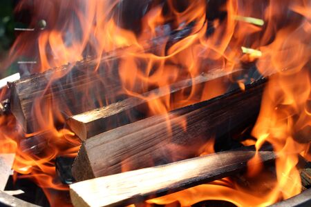 Charred wood and bright flames on dark backgroundの写真素材