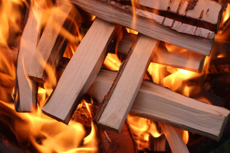 Charred wood and bright flames on dark background