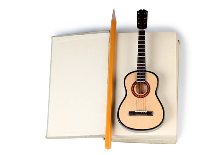 Old book and guitar on a white backgroundの写真素材