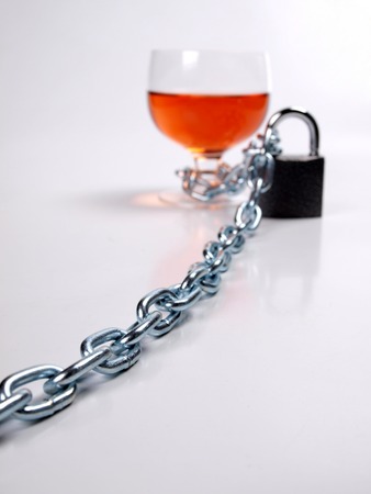 Wineglass of whiskey and metal chainの写真素材