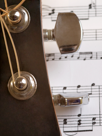 Acoustic guitar trunks on the background of sheet with notesの写真素材