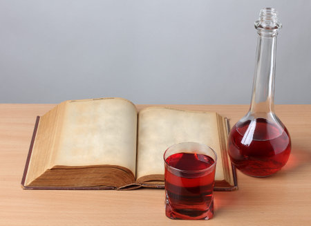 Glass of wine and book on a wooden tableの写真素材