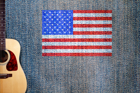 Acoustic guitar and American flag on a background of denimの写真素材