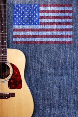 Acoustic guitar and American flag on a background of denimの写真素材