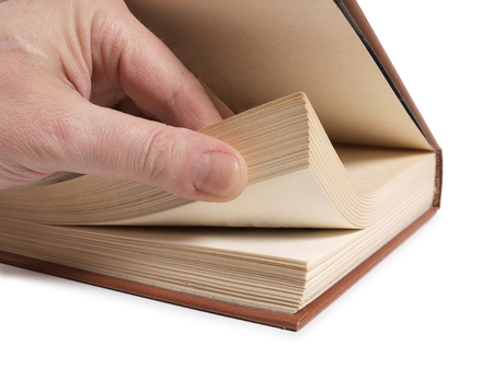 Old classic book and hand on white backgroundの写真素材