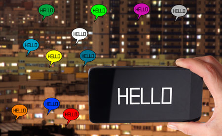 Smartphone in hand on background of large urban houses. Internet connection imageの写真素材