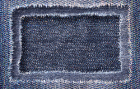 Several layers of denim lie on top of each other. A hole in the middle and a place for text