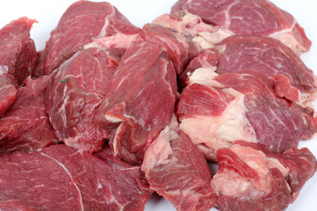 Pieces of chopped red meat on a white background