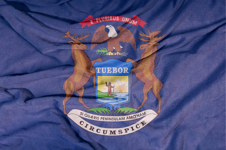 Flag of the American state flies in the wind. Colored background on fabric