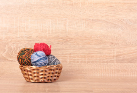 Multicolored balls of wool on a wooden tableの写真素材