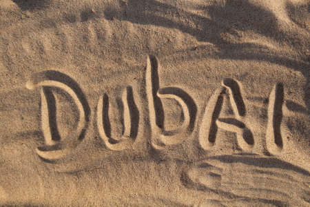 Sand on the beach and the inscription Dubaiの写真素材
