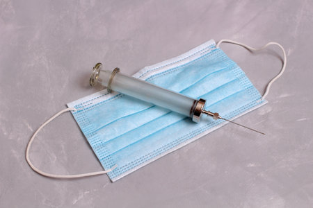 Disposable medical glasses syringes lie on stone tableの写真素材
