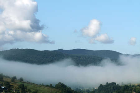 morning mountain fog descending on the villageの写真素材