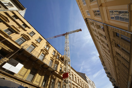 crane between buildings, against the blue sky