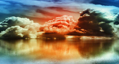 Abstract vibrant colored clouds over a calm sea. Small ripples on the water.の写真素材
