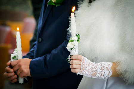 Newlyweds holding in their hands wedding candlesの写真素材