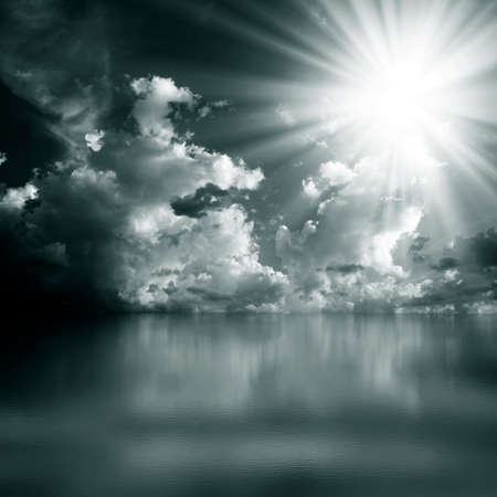 Saturated monochrome clouds and sun over the sea. Blue watercolor.の写真素材