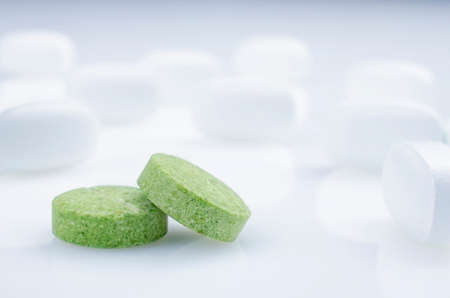 Close-up. Two green pills on a light background, and white pillsの写真素材