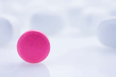 Close-up. Pink pill on a light background, and white pillsの写真素材