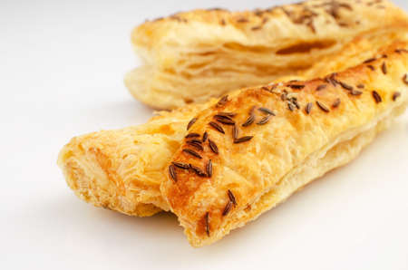 Confectionery theme. Puff pastry, topped with caraway seeds, on white surface.の写真素材