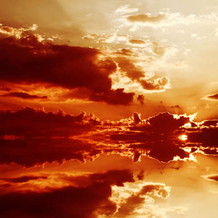 Red sunset over the sea, rich in dark clouds, rays of lightの写真素材