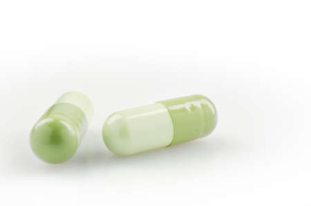 Medical theme. Bright green capsules on the white surface. Closeupの写真素材