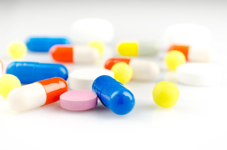 Pharmacy theme. Multicolored Isolated Pills and Capsules on the White Surface. Closeup