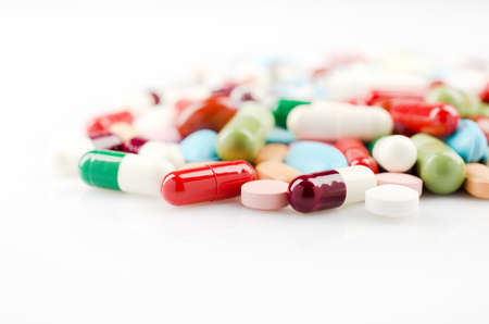Pharmacy theme. Multicolored Isolated Pills and Capsules on the White Surface. Closeupの写真素材