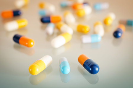 Pharmacy theme. Orange, Yellow, Blue, White Isolated Capsules on the White Surface. Closeup