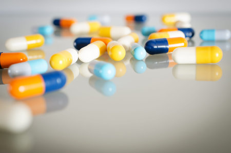Pharmacy theme. Orange, Yellow, Blue, White Isolated Capsules on the White Surface. Closeup
