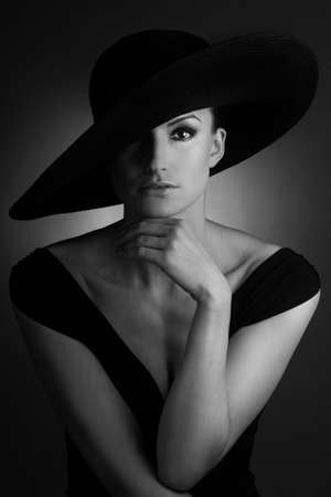 Young beautiful woman with retro big black hatの写真素材