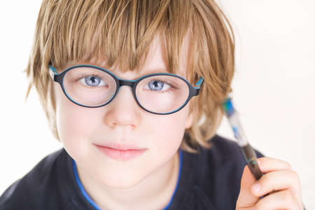 Beautiful boy with glasses and painting brush in handの写真素材