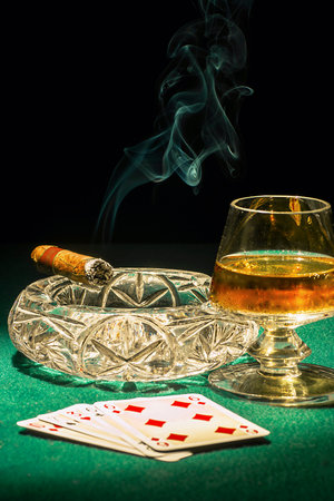 Cigar switched on. Cards and the drink in the glassの写真素材