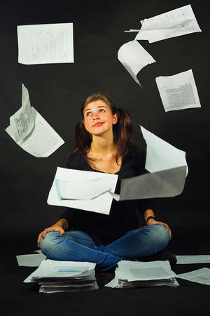 Girl amongst scattered sheetsの写真素材